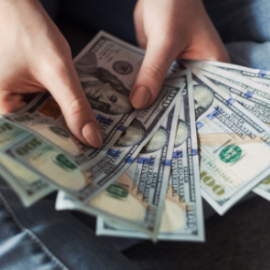 hand holding large amount of cash